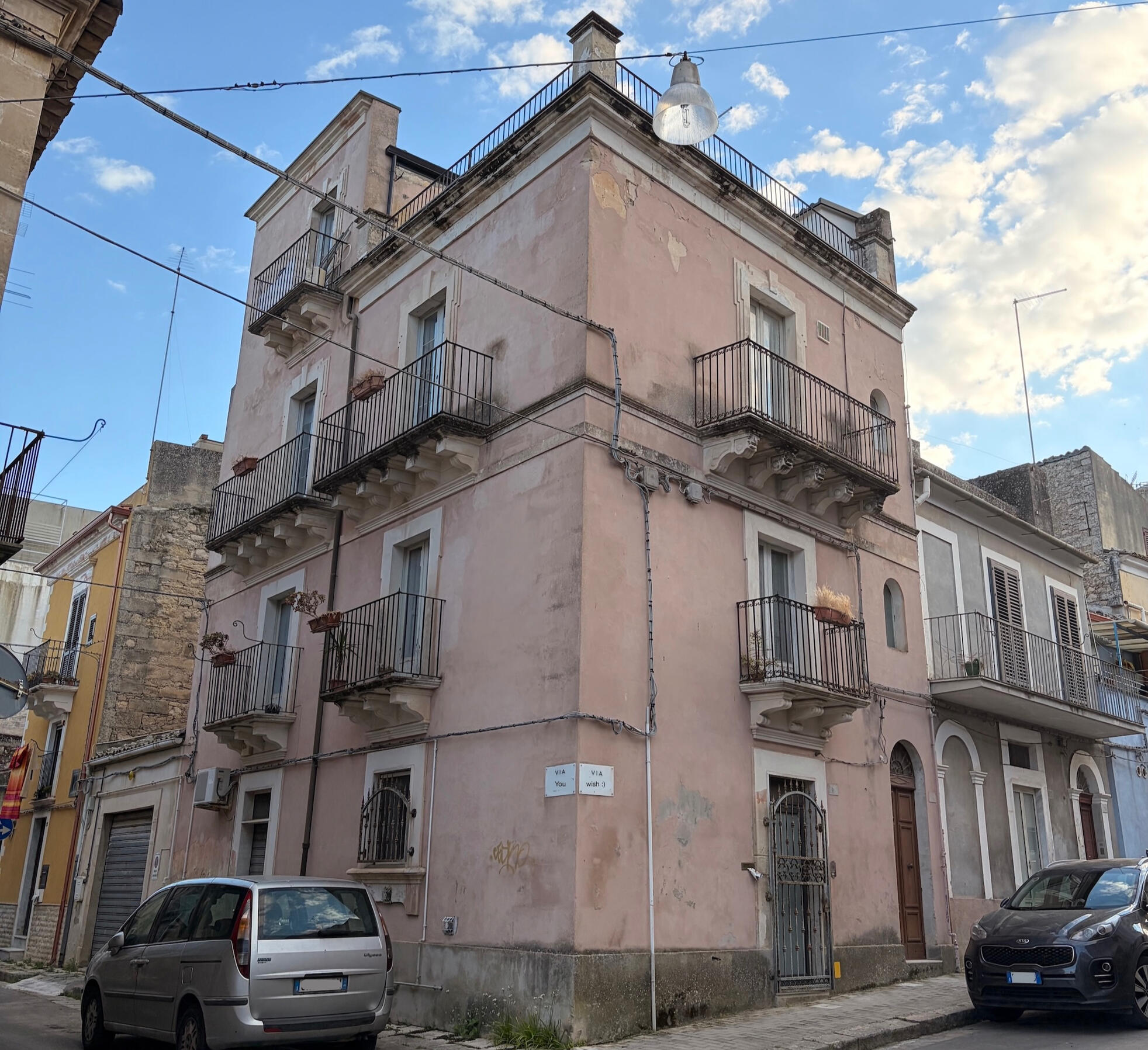 The house in Ragusa Corner house in Ragusa, it's pastel pink and has balconies